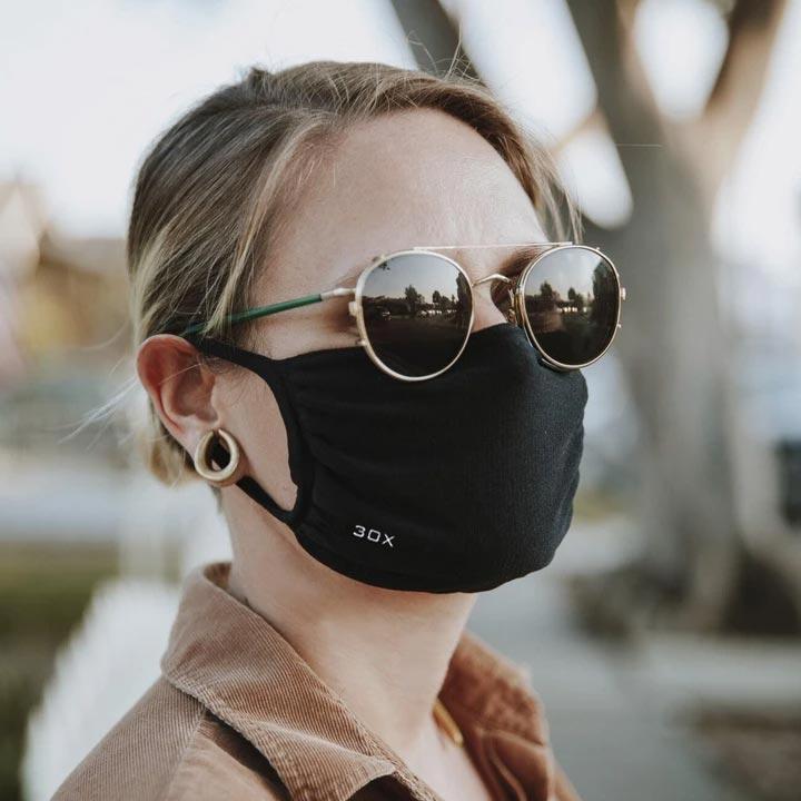 30X Mask, black ear loop mask, worn by a woman in sunglasses