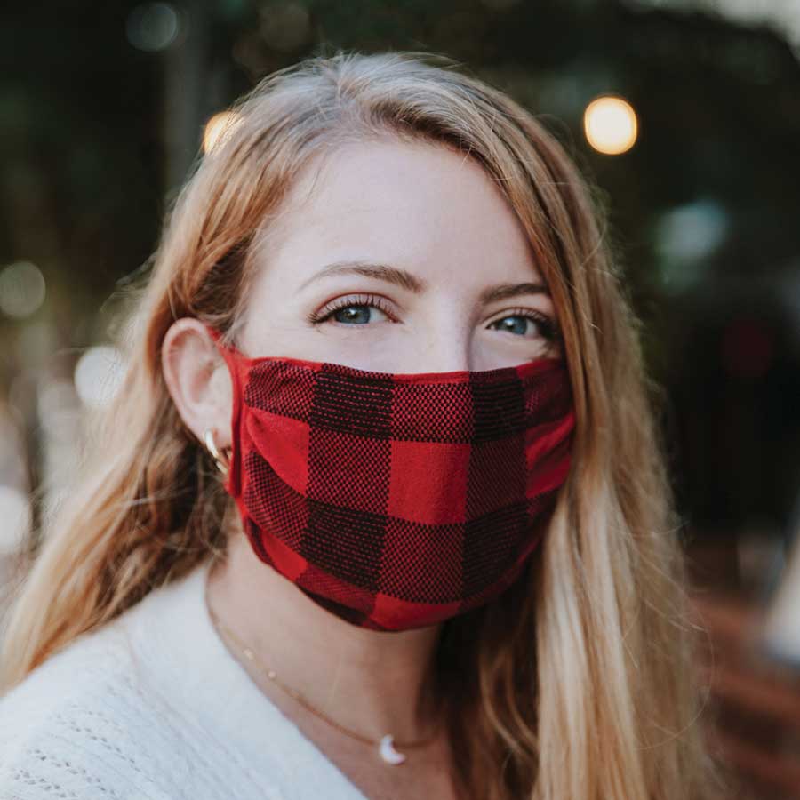 30X Mask, red buffalo plaid, ear loop mask, worn by a young woman outside