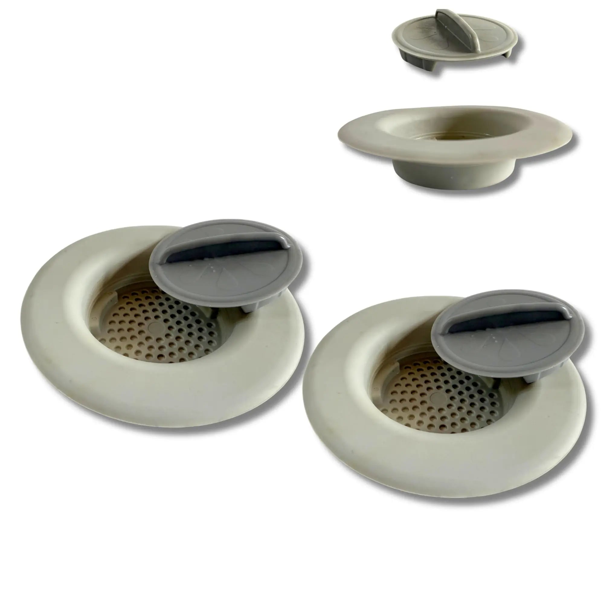 Beige plastic drain stoppers with gray flip-top lids for commercial kitchen sinks