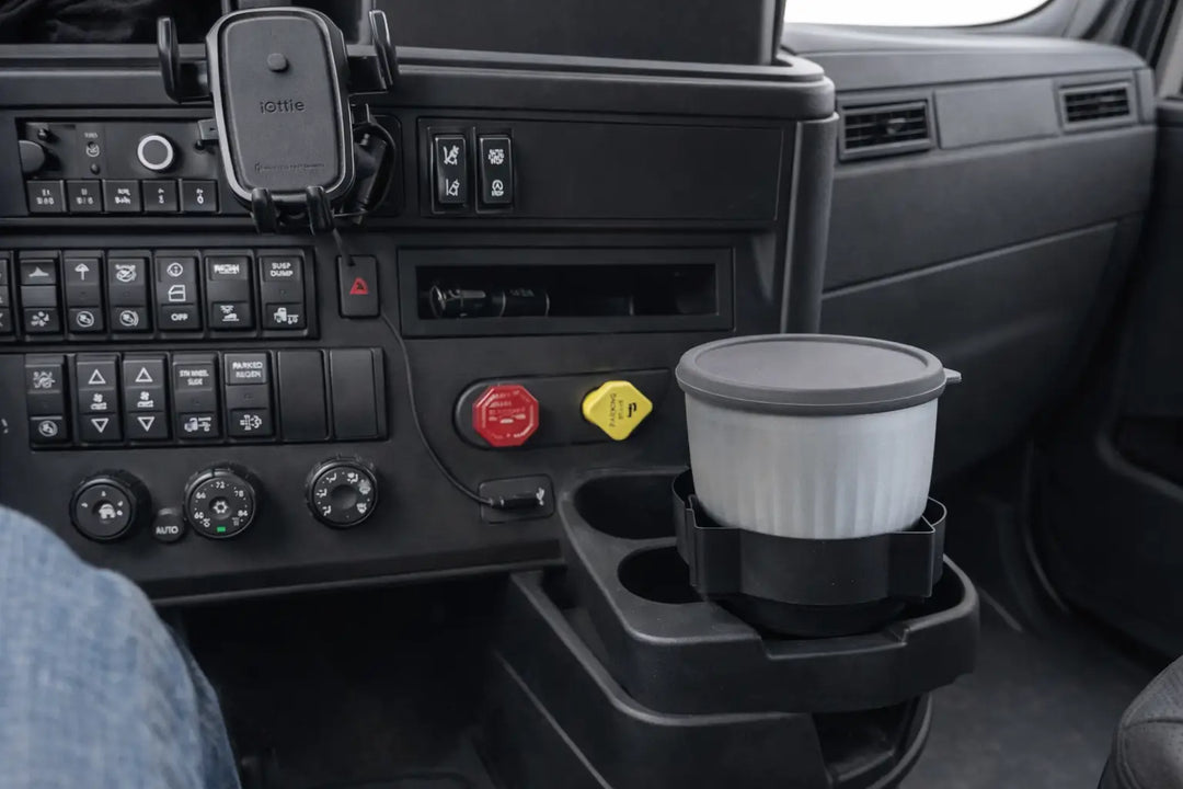 White ribbed travel mug with gray lid in black cup holder for truckers