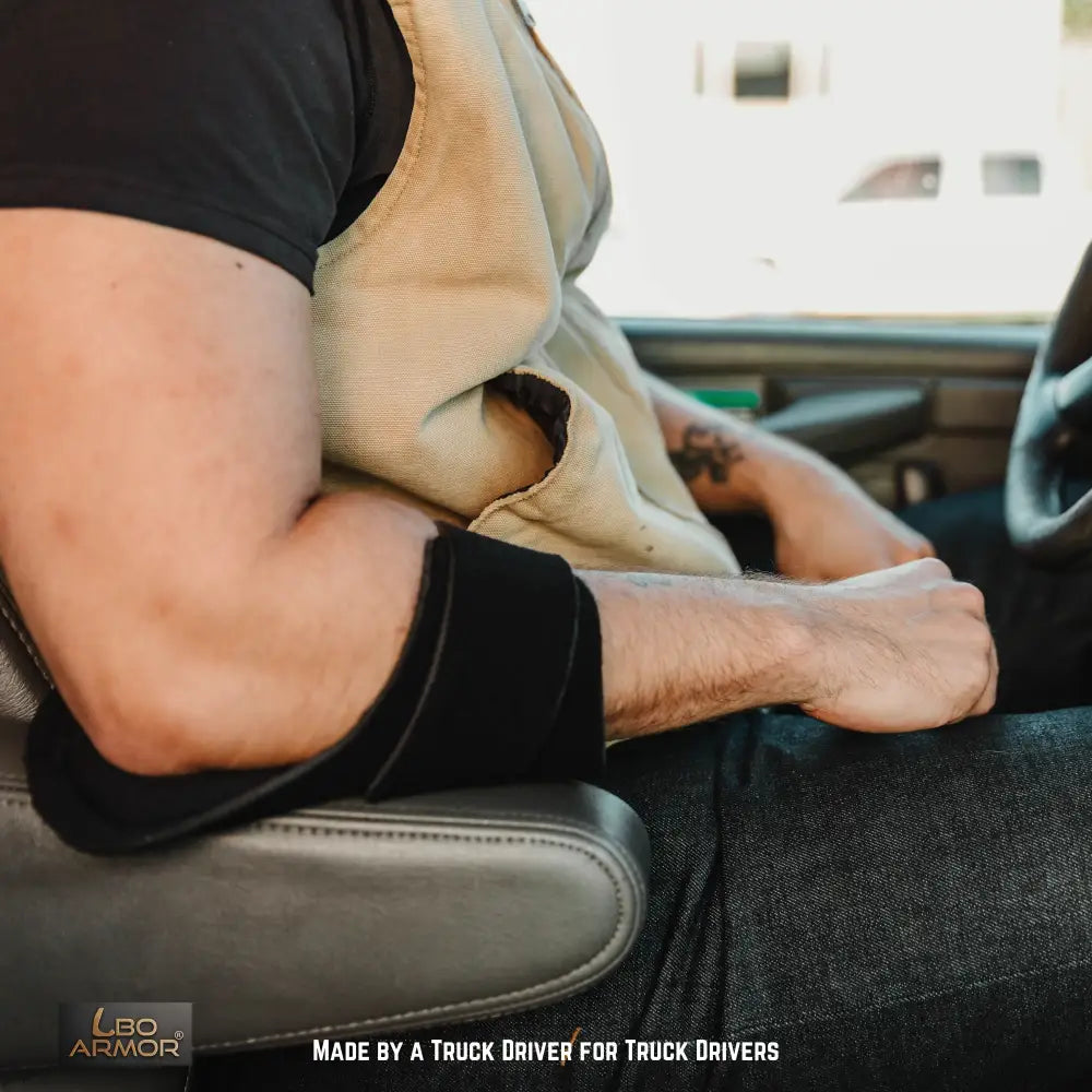Truck driver resting elbow on supported armrest to reduce pain-related distraction during long-haul driving