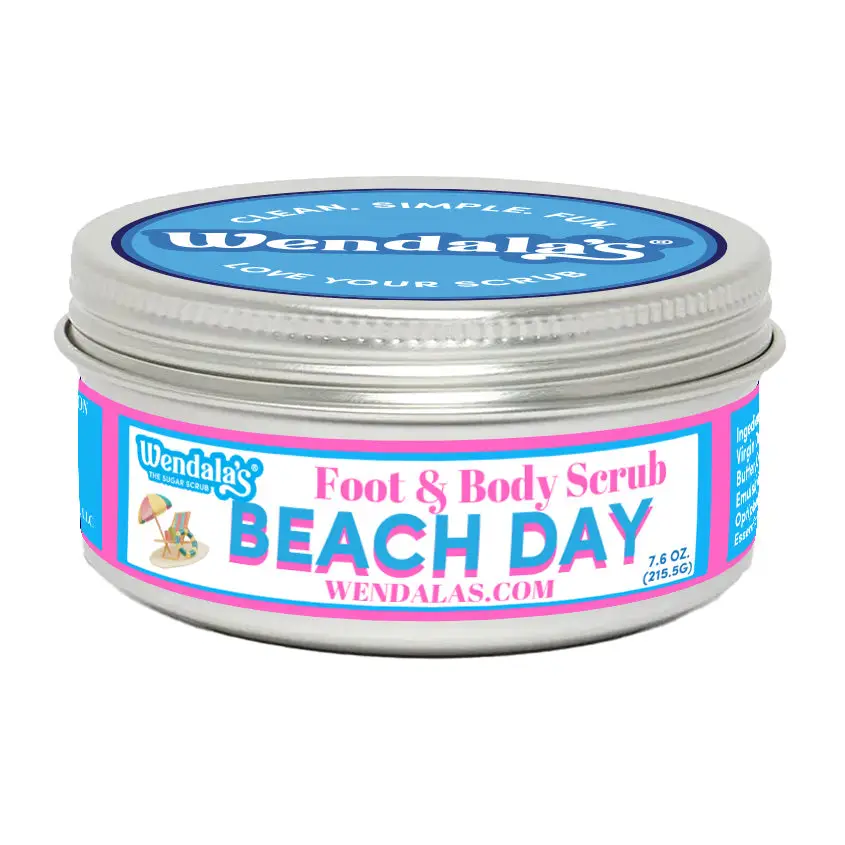 A silver metal jar of wendalas beach day foot and body scrub with vibrant pink and blue label featuring unrefined shea butter and organic coconut butter