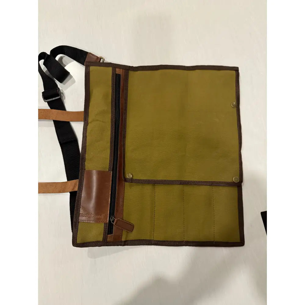Olive green canvas knife roll with brown leather trim and dedicated knife pockets in waxed canvas knife bag design