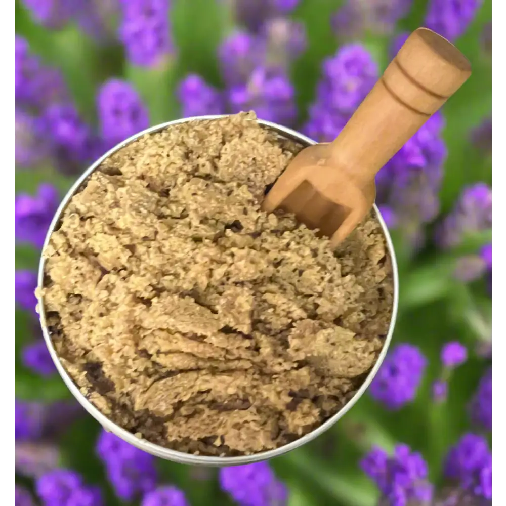 A rustic wooden spoon in a silver bowl of coffee scrubs with organic coconut coarse brown granules for body scrub coffee lavender