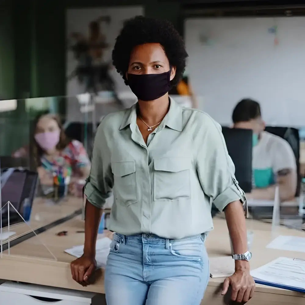 A woman wearing a black breathable smart temp face mask with 30xmask ear loop for all-day protective comfort