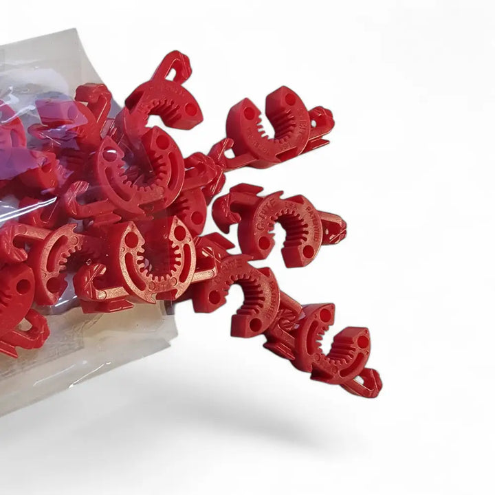 Red plastic c-shaped pipe clamps with textured grips for flexible plant support and garden stakes by c-bite green clips