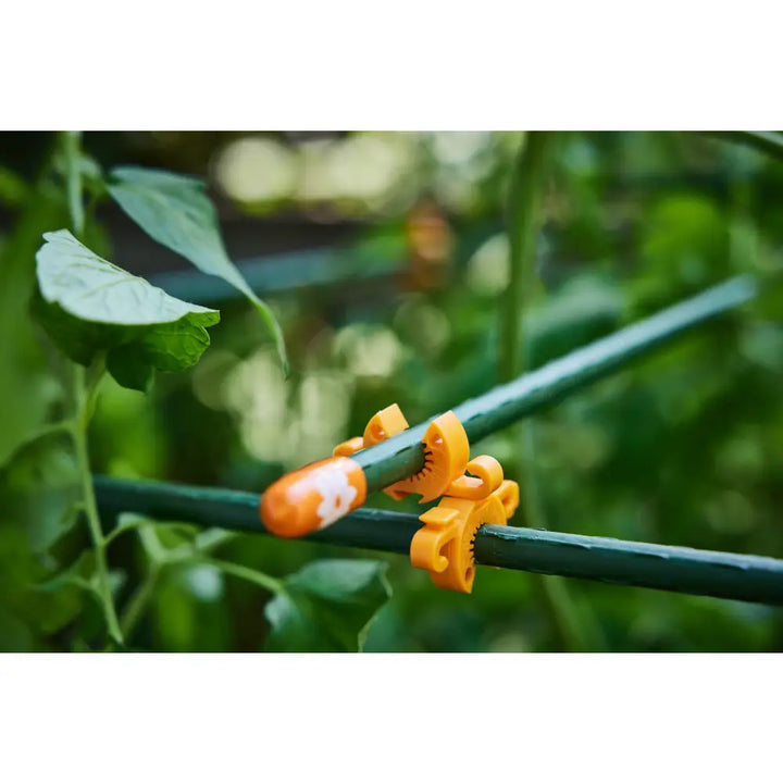 Bright orange plastic C-Bite plant support clip with white paw print design for garden plant clips in a 100-pack