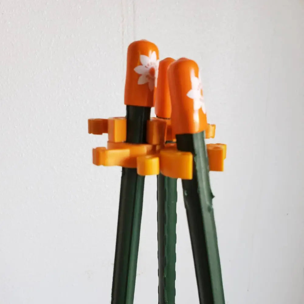 Set of three dark green plastic chopsticks with orange floral tips for garden plant support and 7/16 stakes