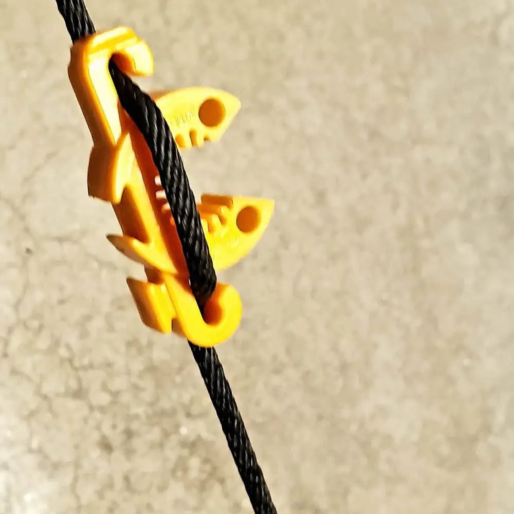 Yellow plastic chameleon shaped c-bite plant support clip clamping black braided cord on 7/16 inch garden stakes