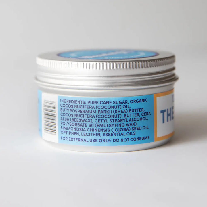 Small silver metal jar with ribbed lid and white label showing chef scrub rosemary mint for beautiful hands hand scrub