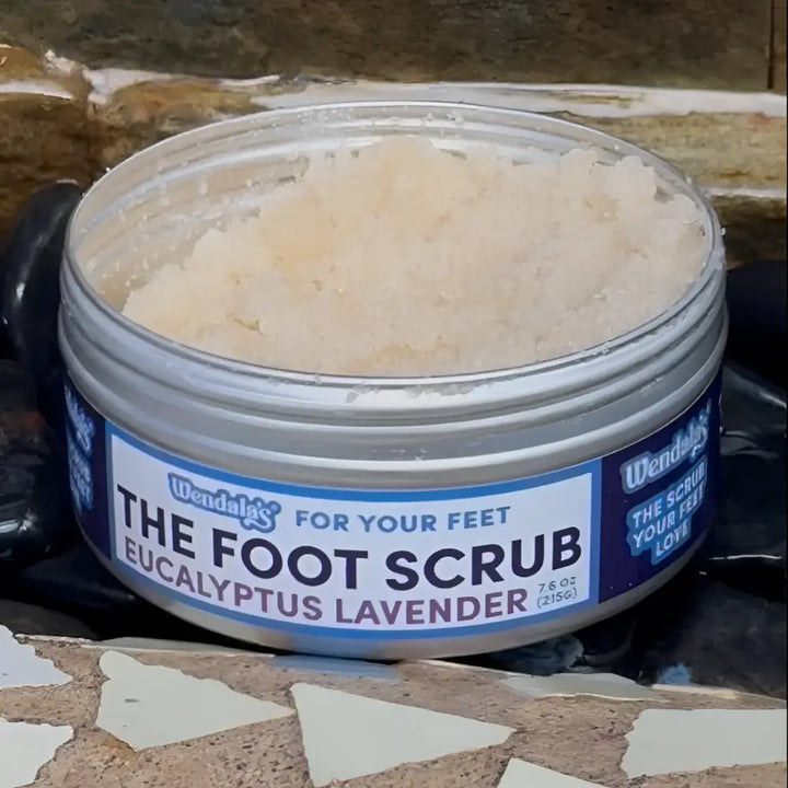 A silver cylindrical container of wendal’s eucalyptus lavender foot scrub with eucalyptus essential oils and light beige granules