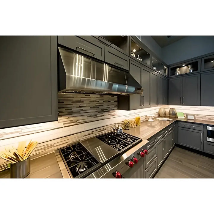 Stainless steel range hood with sleek modern design and reflective surface paired with dimmable wire switch cabinet task light