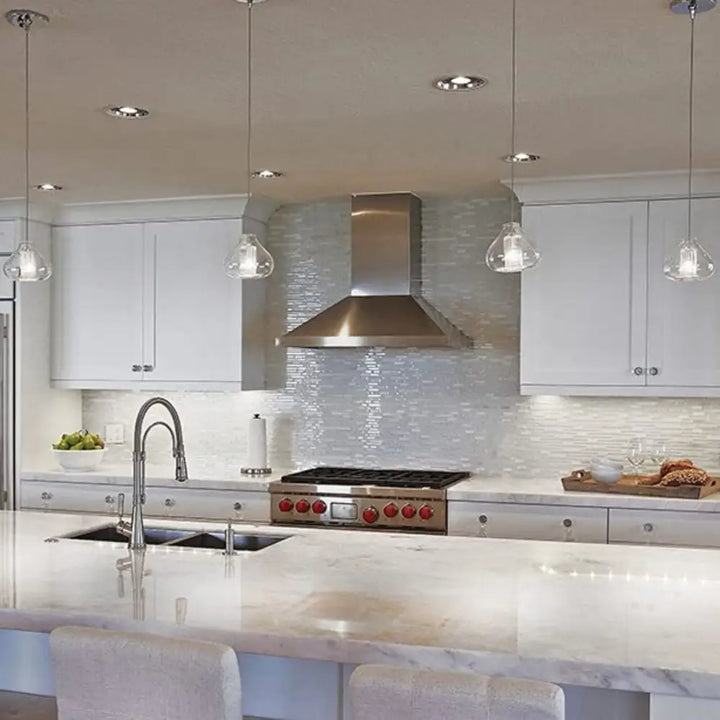 Stainless steel range hood with modern design and red knobs paired with FLI Products dimmable cabinet task light