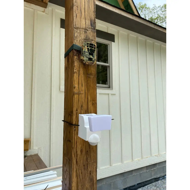 Iq america white plastic motion security flood light with led light and spherical motion sensor mounted on wooden post