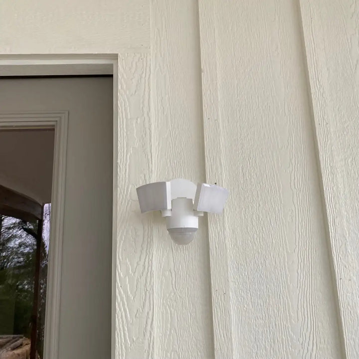 White eave mount motion security light with three angled led panels and central motion sensor iq america led floodlight