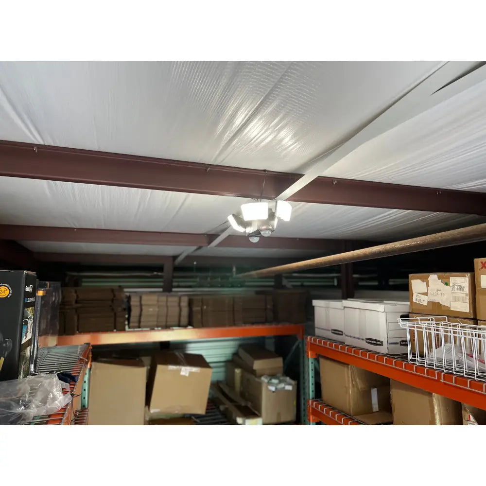 White ceiling with textured surface and brown metal beams featuring iq america battery powered motion security light