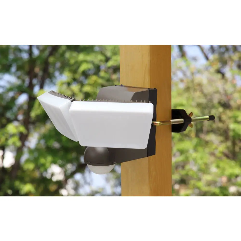 Iq America white and black battery powered motion security light mounted on wooden post with motion sensor floodlight