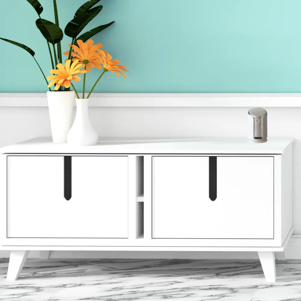 White mid-century modern sideboard with black vertical handles and tapered legs featuring iq america battery powered wireless doorbell chime kit