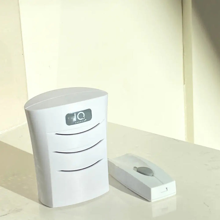 White plastic iq america wireless battery powered door bell chime kit with sleek curved base and three vents