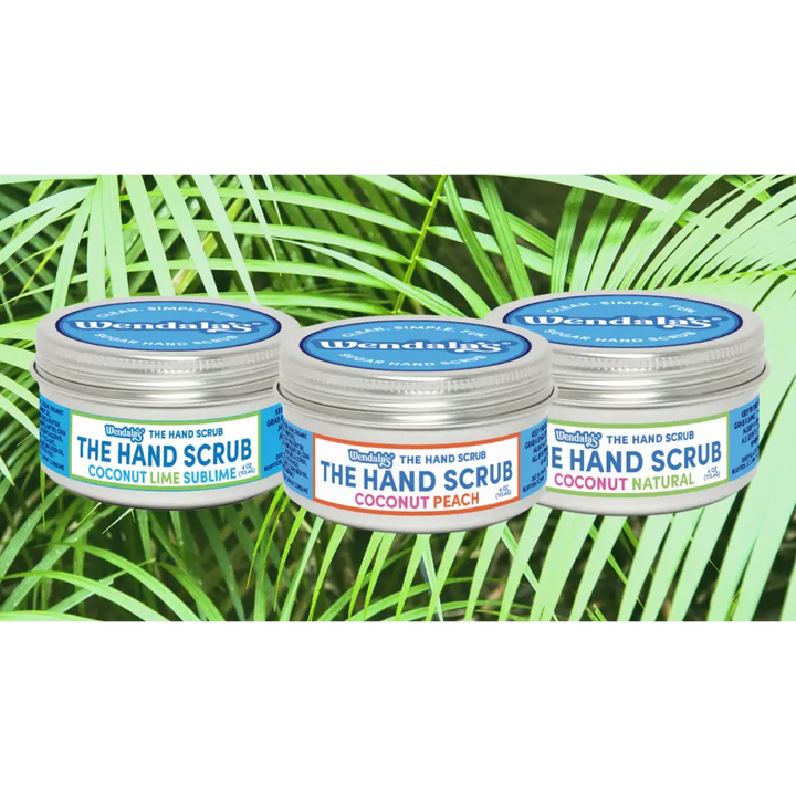 Three small round metal jars of wendala’s®️ coconut hand scrub collection in coconut lime sublime peach and natural flavors