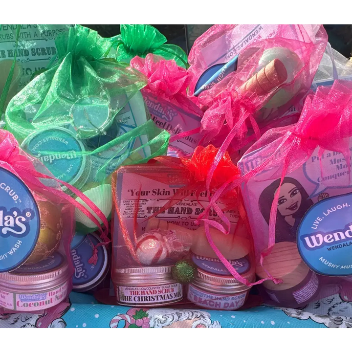 Pink mesh drawstring bags filled with colorful wendala’s®️ peach me a coconut hand scrub collection lotions and scrubs