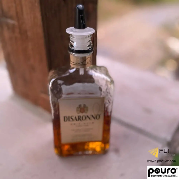 Pouro black liquor pourer spout on Disaronno bottle — twist-open bar pourer for spirits and cocktail bottles