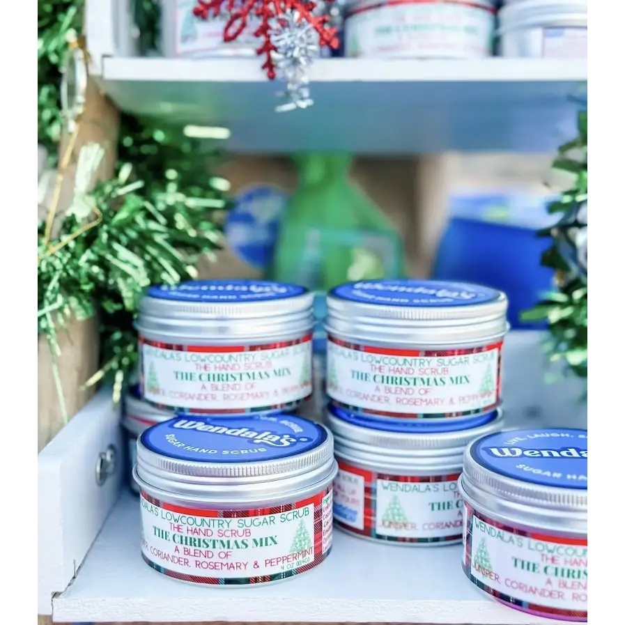 Silver tin containers with blue lids and festive red green plaid labels featuring wendals lowcountry sugar scrub christmas mix hand scrub