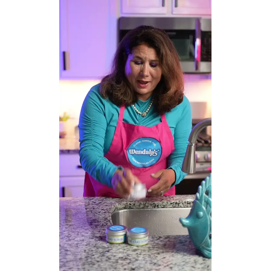 Pink apron with blue wendal’s logo promoting the hand scrub-beach day made with pure cane sugar and organic coconut butter