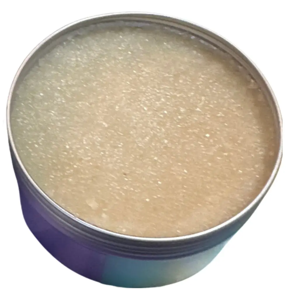 A round metallic tin filled with translucent beige granular hand scrub in rosemary mint scent