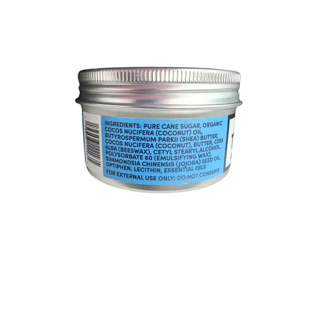 Back side of a silver metal man scrub jar with ribbed lid and blue label listing shea butter and organic coconut ingredients
