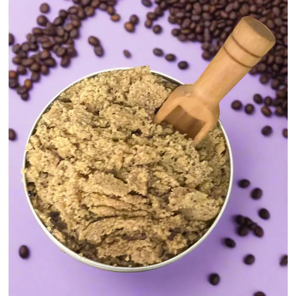 A rustic wooden scoop inside a metal bowl with organic ground coffee for wendalas foot scrub coffee brown sugar lavender