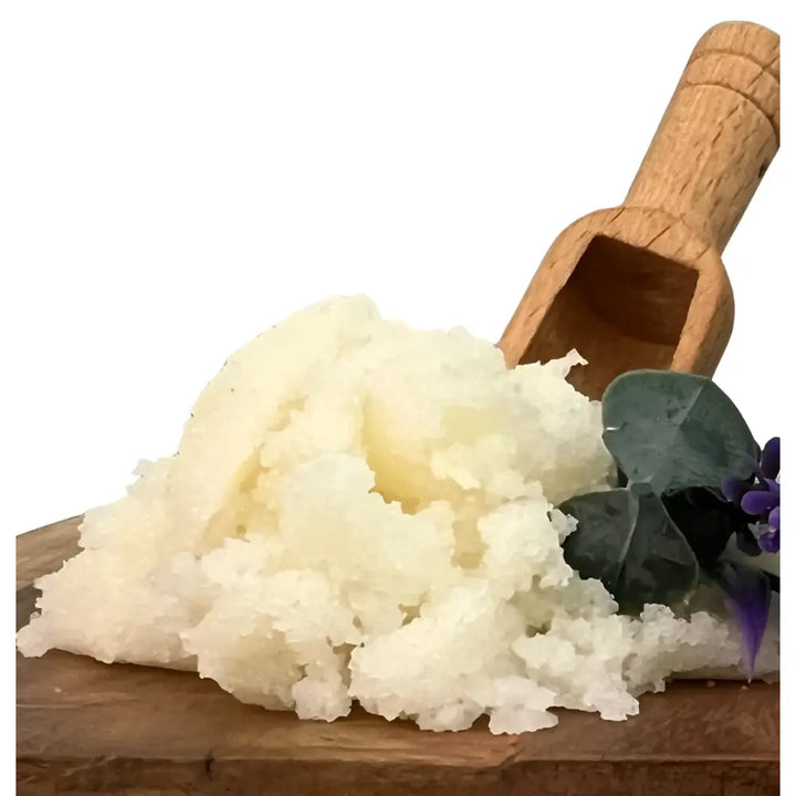 A creamy white, coarse-grained eucalyptus lavender hand scrub with coconut butter and organic coconut oil on a wooden board