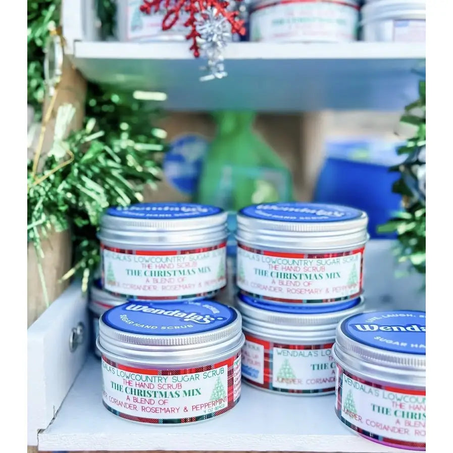 Silver tin containers with blue lids and festive labels featuring wendalas christmas mix sugar hand scrub