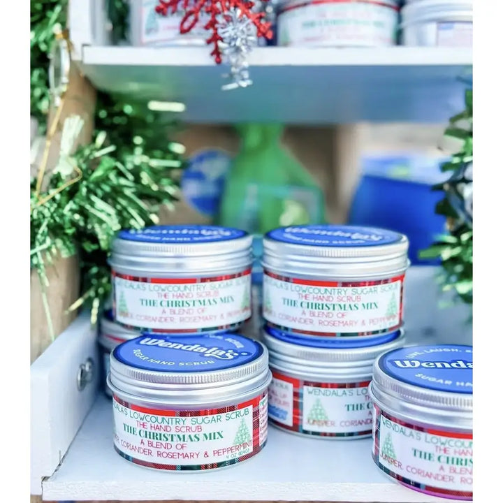 Silver tin containers with blue lids and festive labels featuring wendalas christmas mix sugar hand scrub