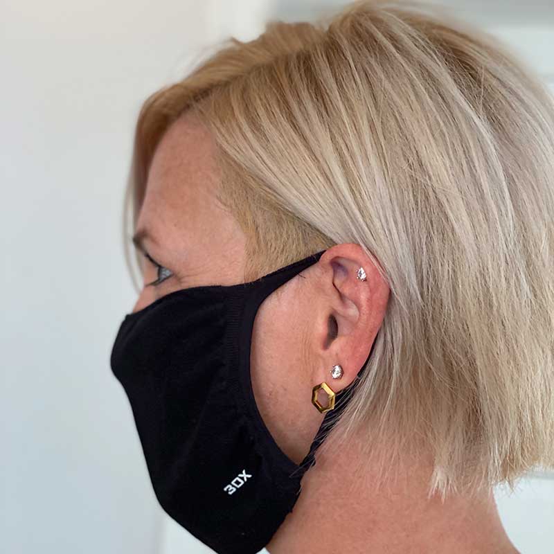 30X Mask, black ear loop mask, worn by a woman, side profile
