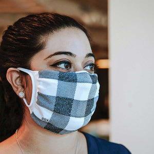 30X Mask, white buffalo plaid, ear loop mask, worn by a young woman